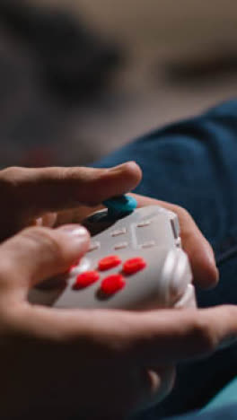 Vertical-Video-Close-Up-Hands-Man-Playing-Video-Game-Controller-Sitting-Sofa-At-Home-2